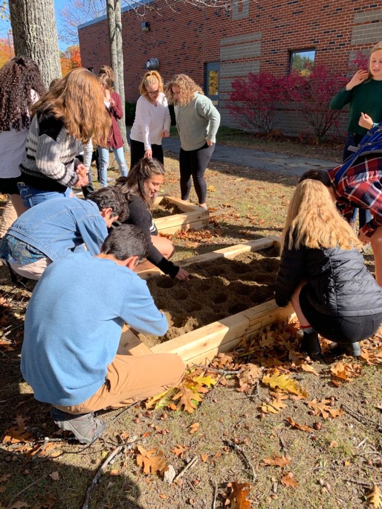 Hall-Dale High School Key Club members help prepare the new Yellow Tulip Hope Garden in Farmingdale. Kayla Lee, center, places bulbs in the ground, with Hailey Acedo and Annalise Rollins behind her. Naomi Lynch is far right. 

