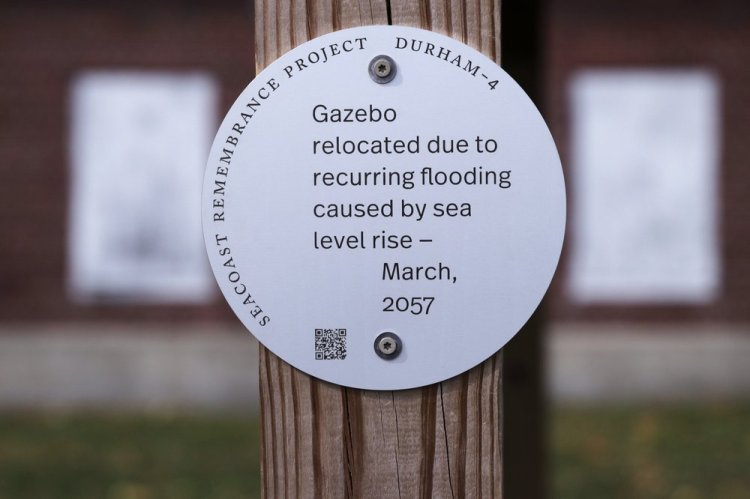 A sign, part of a public design installation by artist Thomas Starr, is displayed on a gazebo outside the University of New Hampshire boathouse in Durham, N.H. Starr, a graphic and information design professor from Boston's Northeastern University, created the project to address possible effects of climate change. 