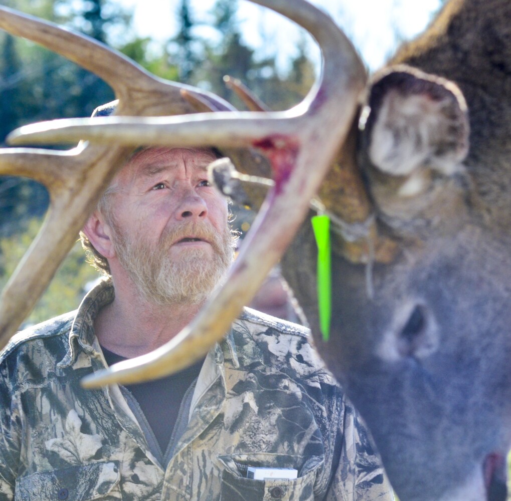 Adam Woodard looks up at the scale Saturday at Tobey's Grocery in China, where his deer weighed n at 198 pounds. Saturday was the first day of firearms deer hunting season for Maine residents only.