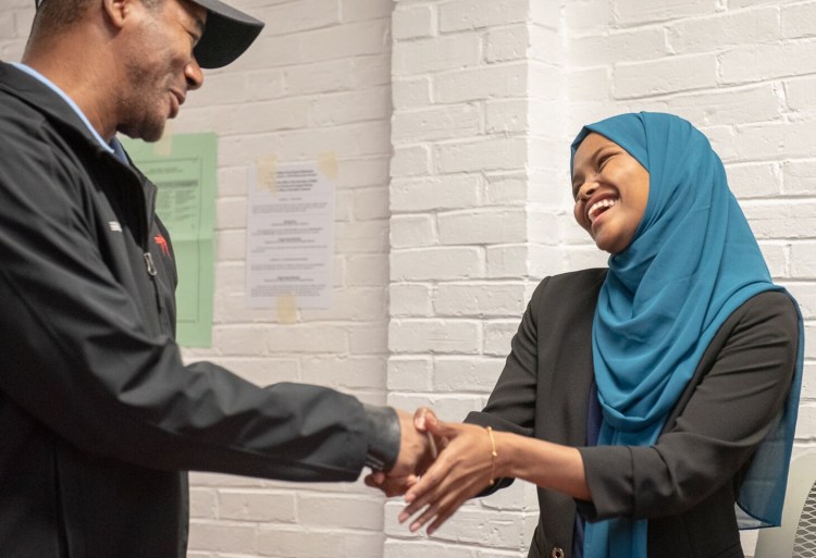 Lewiston City Council Ward 1 candidate Safiya Khalid greets a voter at the Lewiston Armory on Tuesday morning.