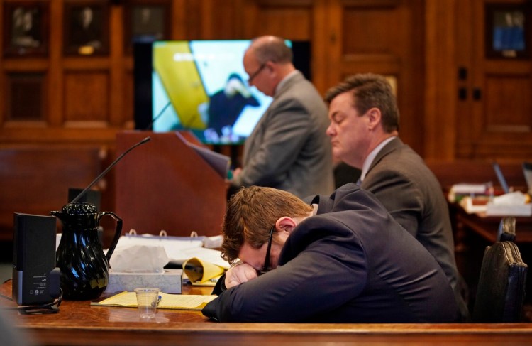 Noah Gaston listens with his head in his hands as a video interview plays during the second day of his trial in Cumberland County Superior Court on Thursday. Gaston is charged with murder and manslaughter in the shooting death of his wife, Alicia Gaston, in their Windham home in January 2016.