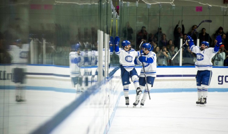 Colby's Kienan Scott, center, celebrates a first period goal against Bowdoin College in Waterville in November. The Mules have only two league wins this season.