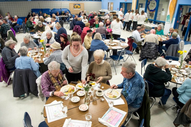 Madison Area Memorial High School sophomore Riley Garland, left center, serves a piece of lemon meringue pie to Sadie Sturtevant, left, Linda Adams, right center and David Adams, far right, during a free Thanksgiving dinner hosted by Madison Area Memorial High School on Thursday.
