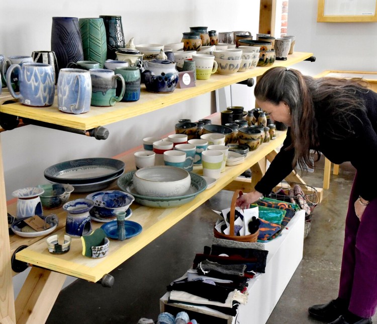 Customer Judy Ayer looks over pottery and knitted items at the holiday bazaar shop at Common Street Arts in the Hathaway Creative Center in Waterville last year.