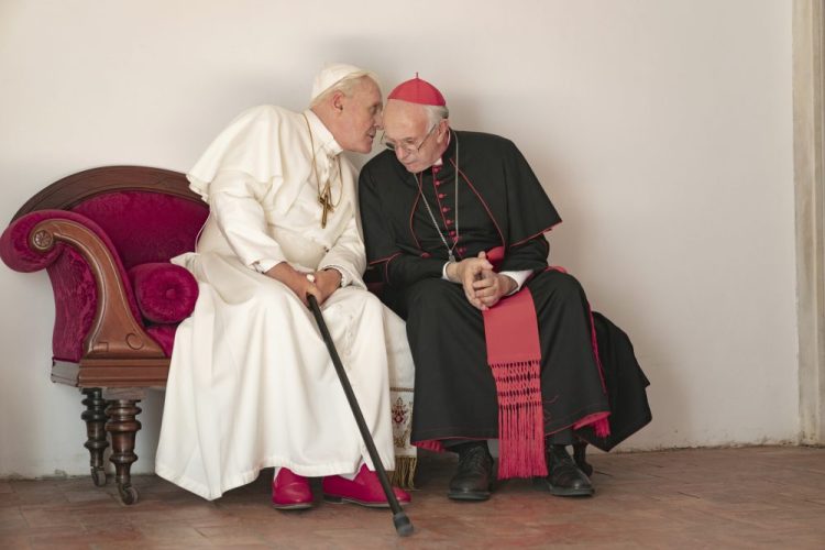 This image released by Netflix shows Jonathan Pryce as Cardinal Bergoglio, right, and Anthony Hopkins as Pope Benedict in a scene from "The Two Popes."   