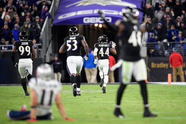 Baltimore Ravens cornerback Marlon Humphrey runs for a touchdown after recovering a fumble by New England wide receiver Julian Edelman on Sunday night in Baltimore.
