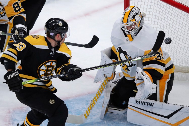 Bruins center Brad Marchand tips the puck past Penguins goaltender Matt Murray in the first period of Boston’s 6-4 win on Monday in Boston. Marchand scored twice and Boston won its sixth straight.
