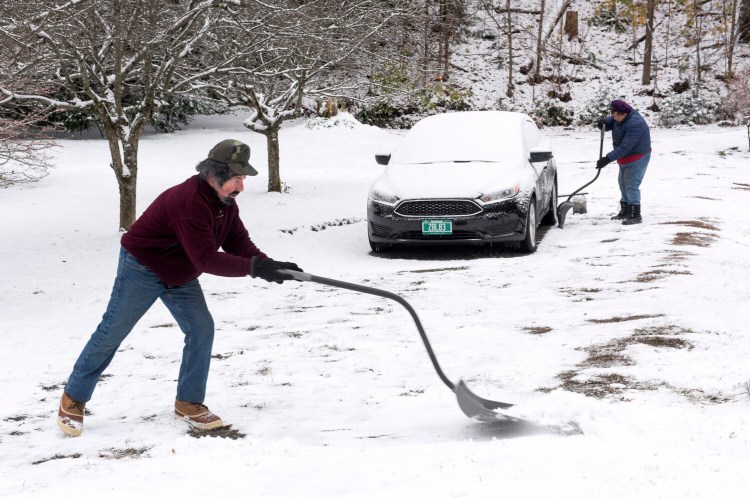 Frank and Barbara Pascarelli shovel snow from their driveway in White River Junction, Vt., on Tuesday. "I like being outdoors, but I can think of better things to do," said Frank Pescarelli. 