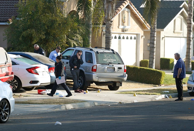 Investigators work Monday in the driveway where the shooting happened at a weekend house party in Fresno, Calif.