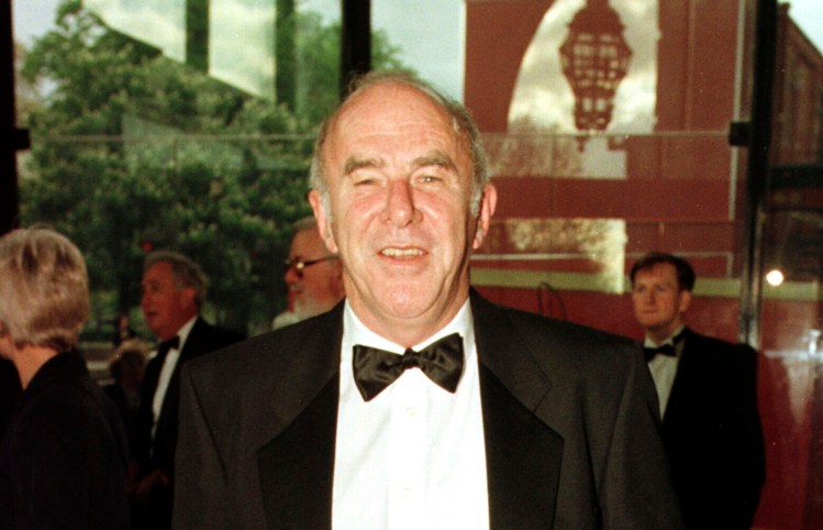 In this April 24, 1997, photo, Clive James arrives at the Royal Albert Hall for the BAFTA award ceremony. After abandoning studies for a doctorate, James made his breakthrough as a writer with a 1972 essay in the Times Literary Supplement about the American literary critic Edmund Wilson.