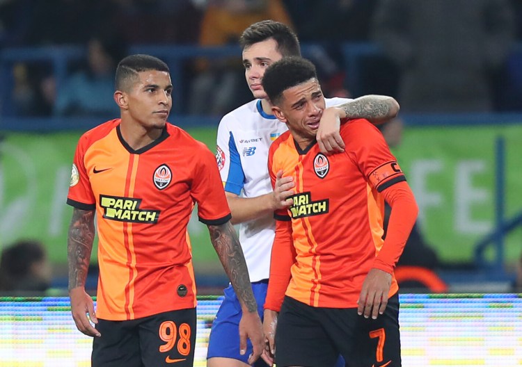 Shakhtar's Brazilian player Taison, right, reacts as he leaves the pitch after he was red-carded for his reaction on racial abuse, while Dynamo Kyiv Mykola Shaparenko, center, calmed him down, during Premier League soccer match in Kharkiv, Ukraine, on Nov. 10, 2019. Shakhtar's Dodo, left, looks on.