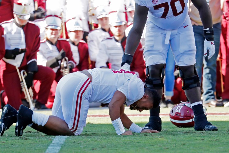 Alabama quarterback Tua Tagovailoa struggles to get up during the first half Saturday in Starville, Miss. Tagovailoa suffered a hip in jury and did not return to the game. 