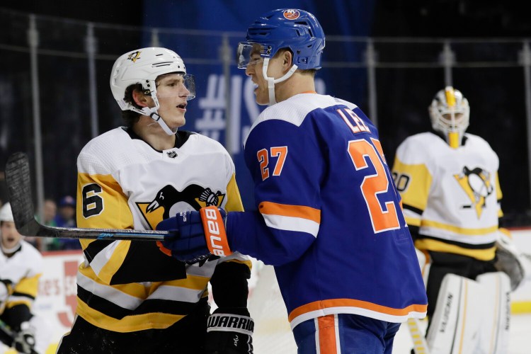 Pittsburgh's John Marino, left, and New York's Anders Lee exchange words during Thursday's game. The Islanders and have at least a point in 16 straight games. 
