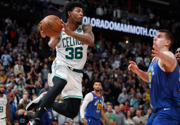 Guard Marcus Smart pulls in a rebound during the Celtics' 96-92 loss to the Denver Nuggets on Friday in Denver. Smart is upset with comments made by a fan during the game and what he said was a lack of response by security at the arena.