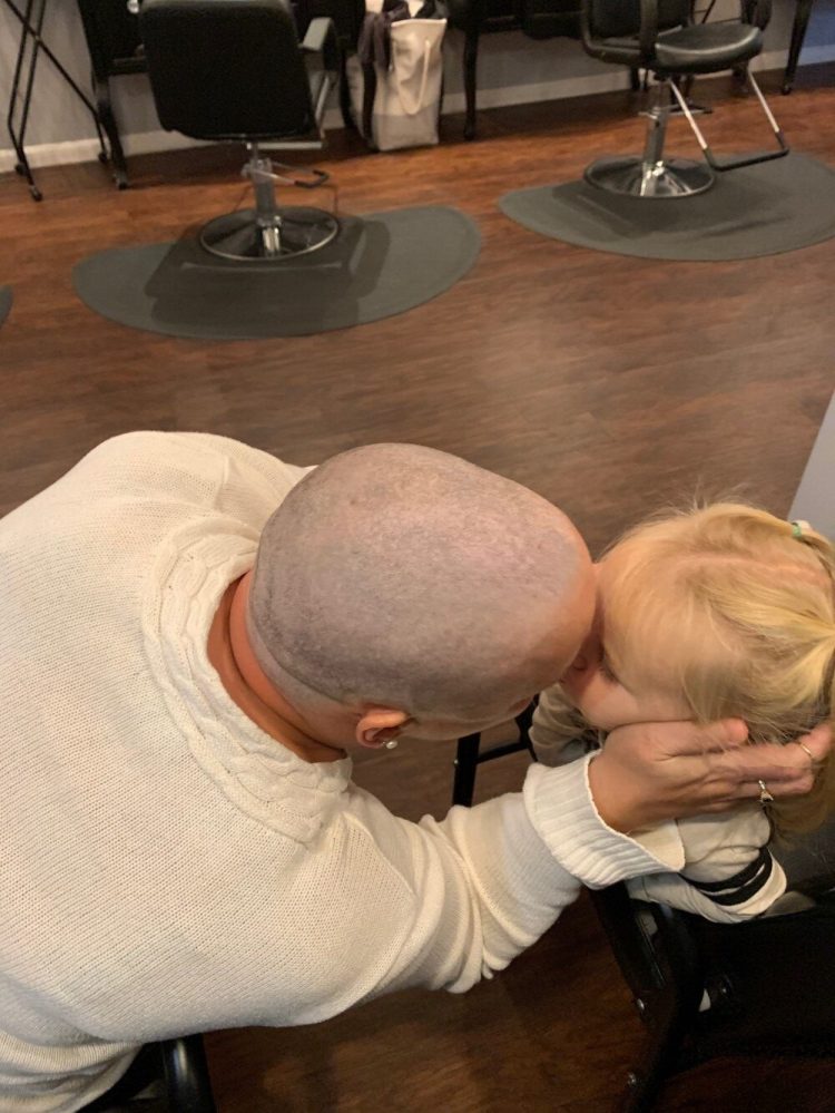 Christine Landes is seen Oct. 17 at Love is in the Hair salon in Augusta with granddaughter Reeslyn Peavey, 2, after Landes had her head shaved. The appointment came about two months after her cancer diagnosis. 