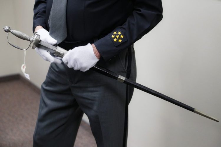 A sword, wielded in the American Revolution and the War of 1812, is handled by Hamilton County Sheriff Jim Neil on Wednesday during a news conference to update the investigation into its ownership, in Cincinnati. Police in Connecticut seized the sword, believed to have been stolen in Cincinnati some 40 years ago, last month just hours before it was going up for auction. 
