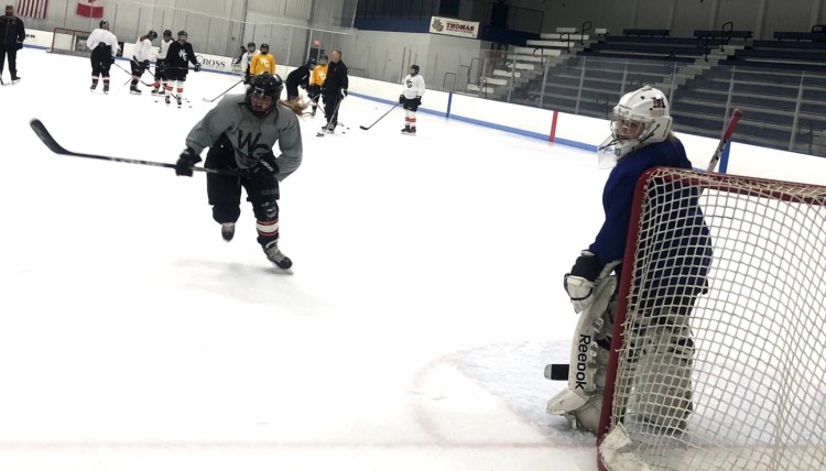Winslow/Gardiner/Cony junior Lindsey Bell, left, and goalie Emma Michaud compete during a practice drill Thursday at the Camden National Bank Ice Vault in Hallowell. The Black Tigers begin their season Saturday.