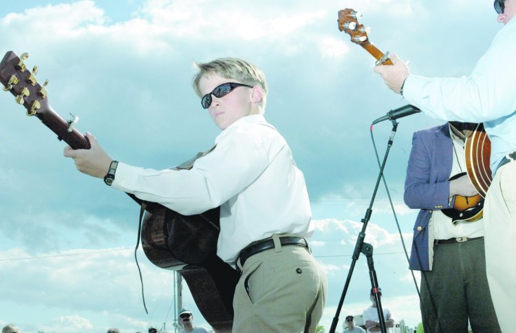 A young member of The Bluegrass Tradition Band plays at what was then the National Folk Festival in Bangor in 2002. The festival has called it quits after 18 years.