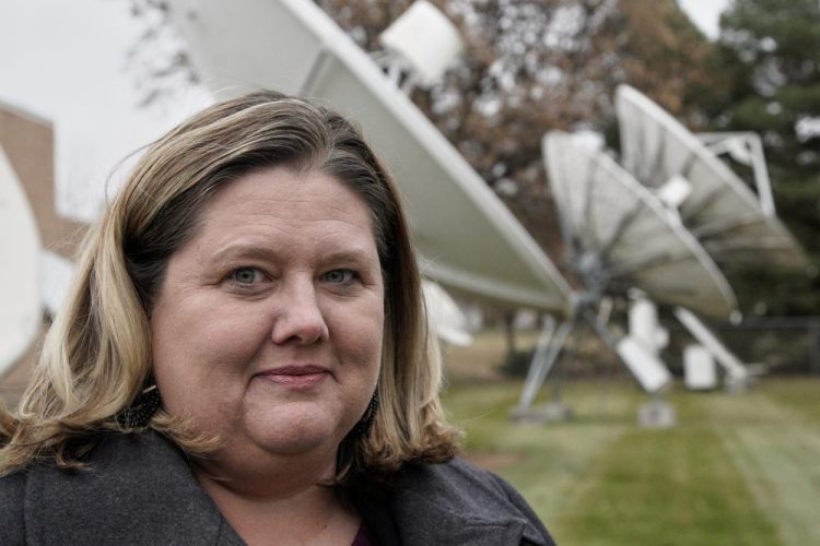 Shannon Booth, vice president and general manager for Gray Television who oversees company-owned Nebraska stations in Lincoln, Hastings and North Platte, poses for a portrait Nov. 21 in front of the KOLN television station's satellite dishes in Lincoln, Neb. 