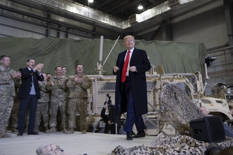 President Trump walks on stage as he arrives to speak to members of the military during a surprise Thanksgiving Day visit to Afghanistan.