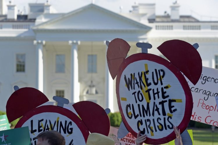 Protesters gather outside the White House in June 2017 to protest President Trump's decision to withdraw the Unites States from the Paris climate change accord. Associated Press/Susan Walsh