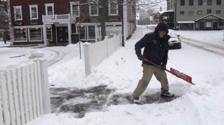 Bill Langley, of the Green Mountain Inn, in Stowe, Vt., shovels snow from a sidewalk on Tuesday. 