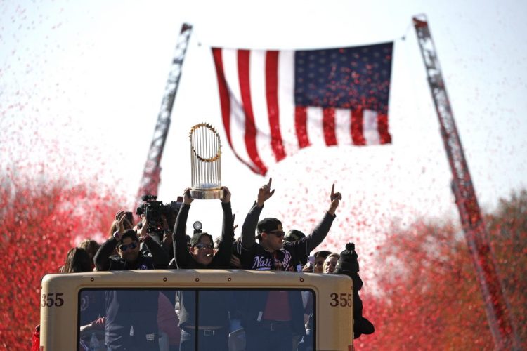 Washington Nationals general manager Mike Rizzo holds up the World Series trophy during a parade to celebrate the team's World Series baseball championship over the Houston Astros on in Washington.