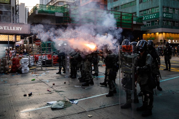 Riot police deploy tear gas on Nathan Road during a protest Oct. 20 in the Mong Kok district of Hong Kong.