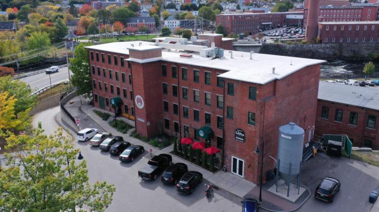 The former mill building that houses The Lofts, a 22-unit apartment complex, and The Run of the Mill Public House & Brewery, a large restaurant and brew pub, is going to auction Thursday. The building is being marketed as an investment property and no tenant changes are expected.