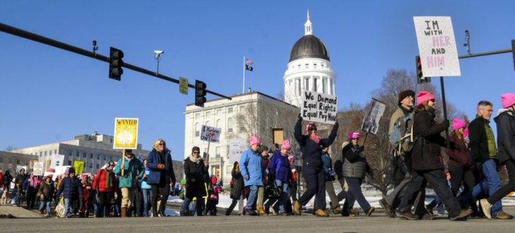 Marchers cross State Street in front of the Maine State House at the beginning of the Maine Women's March 2.0: Power to the Polls in January in Augusta. They started with speakers in the plaza between Cross State Office Building and State House before taking a lap around Capital Park.