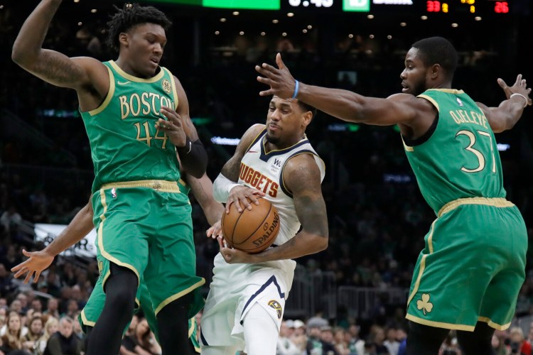 Nuggets guard Monte Morris, center, drives between Celtics center Robert Williams III, left, and forward Semi Ojeleye in the first quarter of their game on Friday night in Boston.