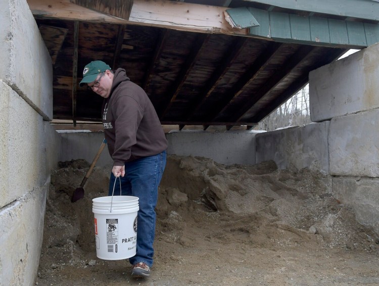 Wes Holland collects a bucket of salt and sand Monday from a shed at Gardiner Public Works. Shoveling two buckets of the mix of melting agent and absorbent for his home was the last step in preparing for the first snowstorm of the season. "I've a got a wood stove," the transplant from Oklahoma to Gardiner  said. "I'm ready for it."  