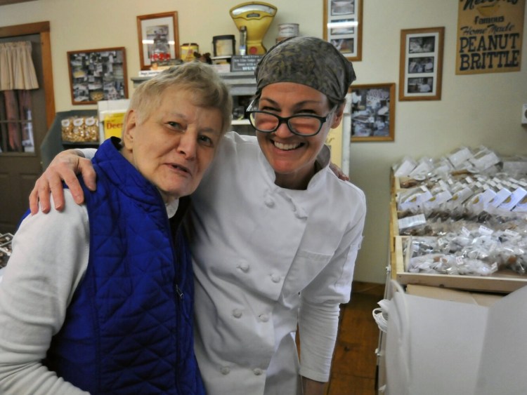 Janet Bernard, right, of Nelson's Candies and longtime customer Sally Goodridge of Pittsfield  embrace Dec. 5 .