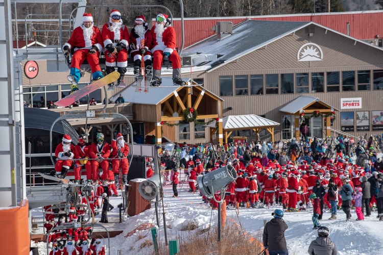 Two hundred and forty people who dressed up like Santa ride the lift at Sunday River in Newry Sunday morning during the 20th annual Santa Sunday fundraiser. They raised $6,200.