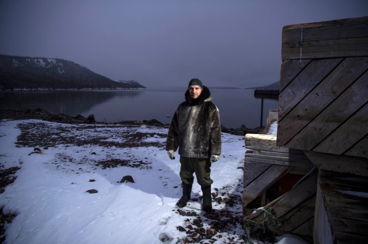 Karl Michelin poses for a portrait at the water's edge of Lake Melville in Rigolet wearing a dickie made of seal skin from a seal he hunted from the bay on Nov. 13, 2019. 