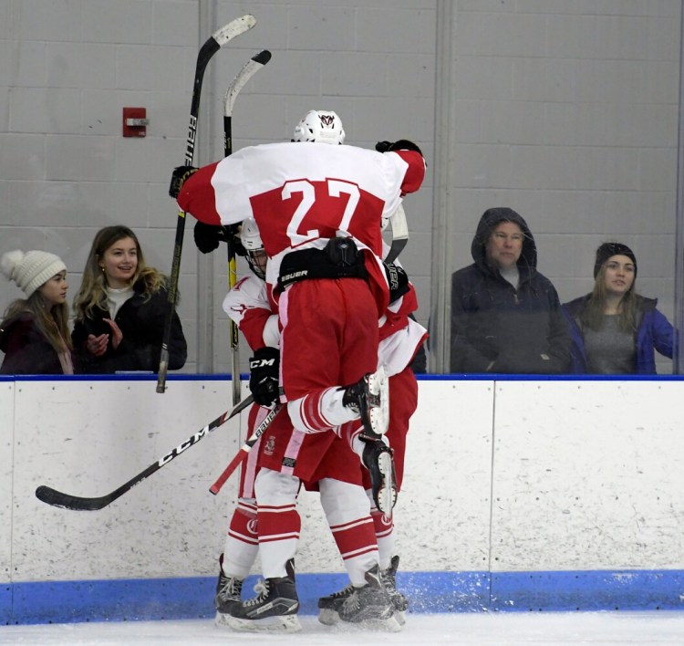 Cony's Zack Whitney leaps into the arms of his teammates after a goal against Gardiner on Thursday in Hallowell.