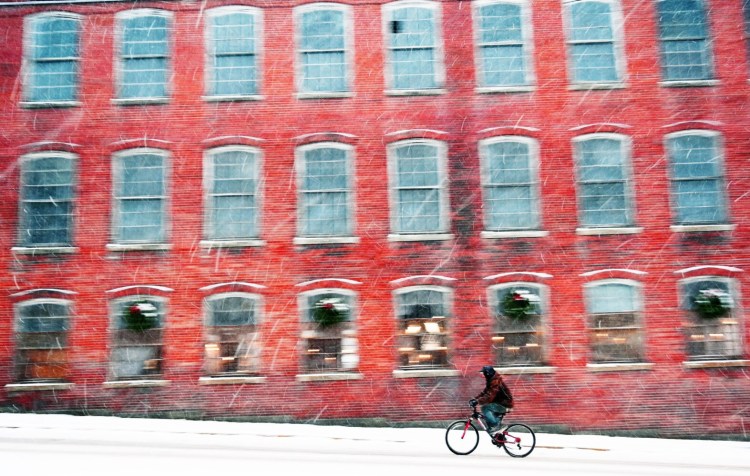 A cyclist makes his way up Main Street in Biddeford during the storm Tuesday that dropped 2-6 inches across the region and made for very slick conditions.