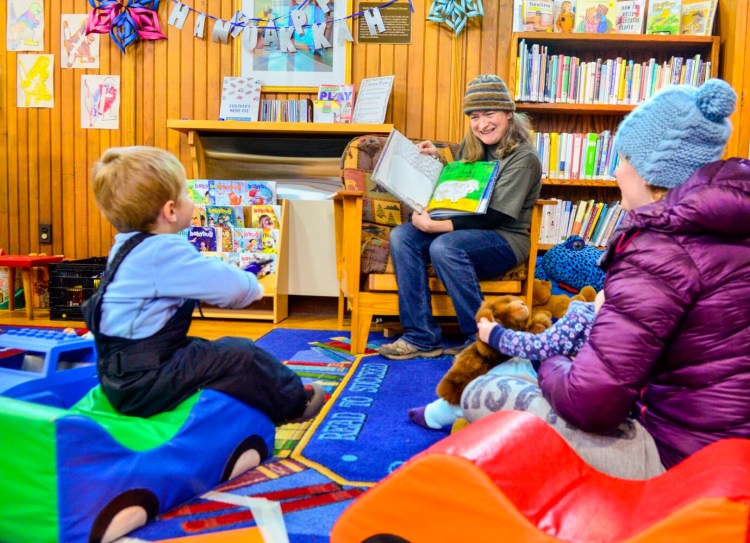 Assistant Librarian Stacie Linkel reads a book to a family during story hour Wednesday at the Hubbard Free Library in Hallowell.