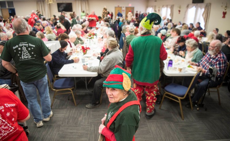 Flo Pouliott, center, waits Wednesday to serve people at the 13th annual Central Maine Family Christmas Dinner at the Elks Lodge in Waterville.  