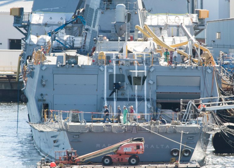 Workers walk across the aft deck of an Arleigh Burke-class destroyer while it is under construction at Bath Iron Works in Bath in 2016. 