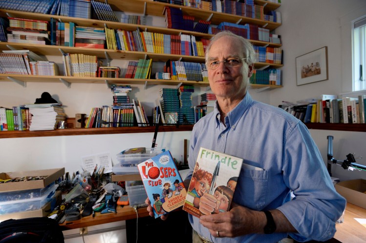 Maine children's author Andrew Clements, with two of his books, "The Losers Club" and "Frindle" in 2017. For decades, Clements wrote late at night, sitting down at his desk after 8 p.m. and sometimes continuing until daybreak.