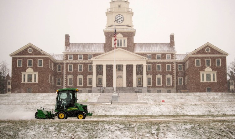 Crews clear snow from the walkway in front of Miller Library at Colby College in Waterville on Tuesday.