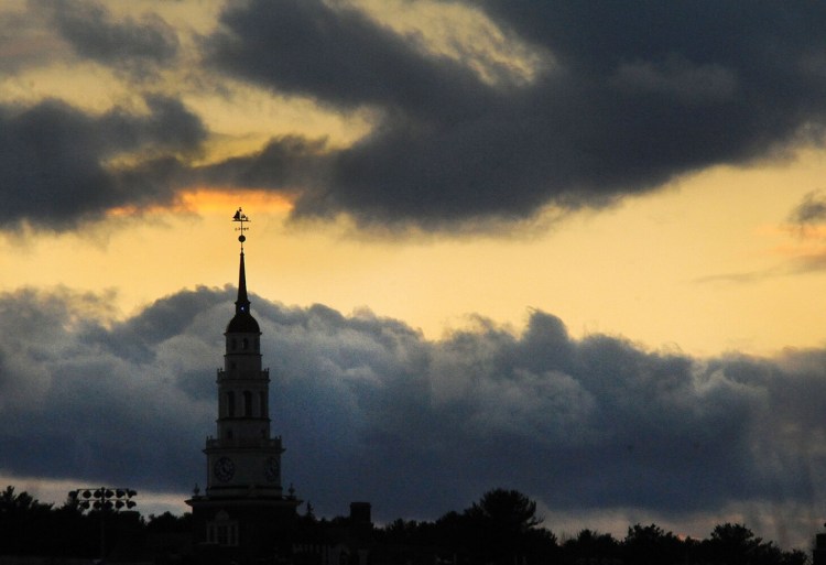 The setting sun backlights a smudge of clouds beyond the Miller Library steeple on the Colby College campus in Waterville on Thursday.