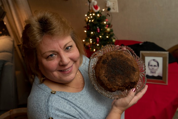 Julie Ruttinger of Tecumseh, Mich., holds a 141-year-old fruitcake, a family heirloom baked by her great-great-grandmother, Fidelia Ford, in 1878. Fidelia, pictured at left, died before the cake was served and the family, out of respect of her memory, decided not to eat it and has instead passed it down for generations. 
