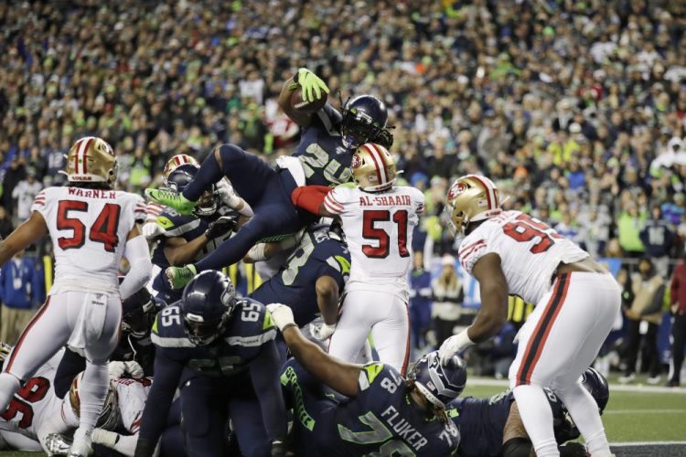 Seattle's Marshawn Lynch scores a touchdown on a 1-yard rush against the San Francisco 49ers during the second half Sunday night in Seattle. The 49ers defense held late to win the game and the division.
