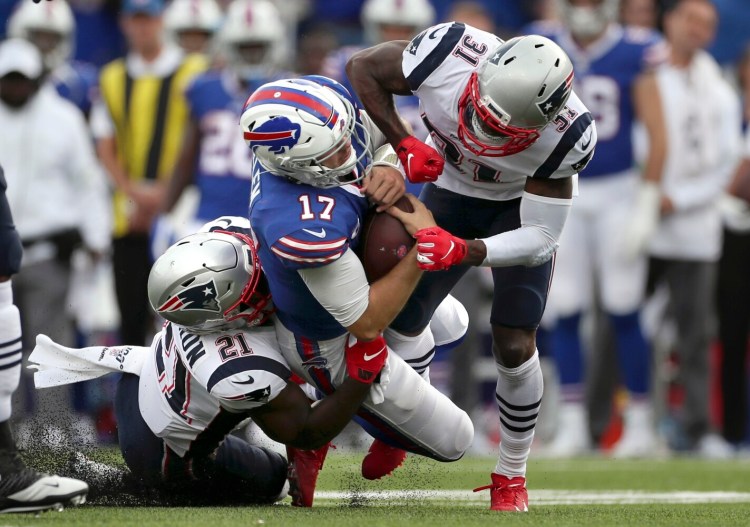 New England Jonathan Jones, right, and and Duron Harmon put a hit on Buffalo quarterback Josh Allenin a game on Sept. 29 in Orchard Park, N.Y. Allen left the field after the play. 