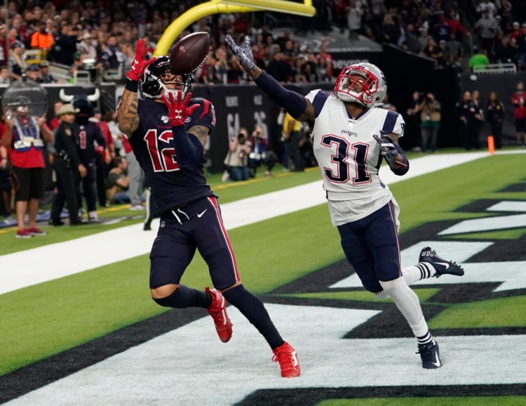 Houston Texans wide receiver Kenny Stills pulls in a pass in front of New England Patriots cornerback Jonathan Jones (31) during the Texans' 28-22 win Sunday in Houston. 