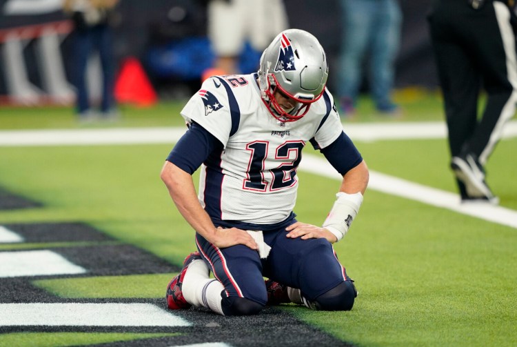 Patriots quarterback Tom Brady kneels on the turf after a play during the second half of New England's 28-22 loss to the Houston Texans on Sunday in Houston.