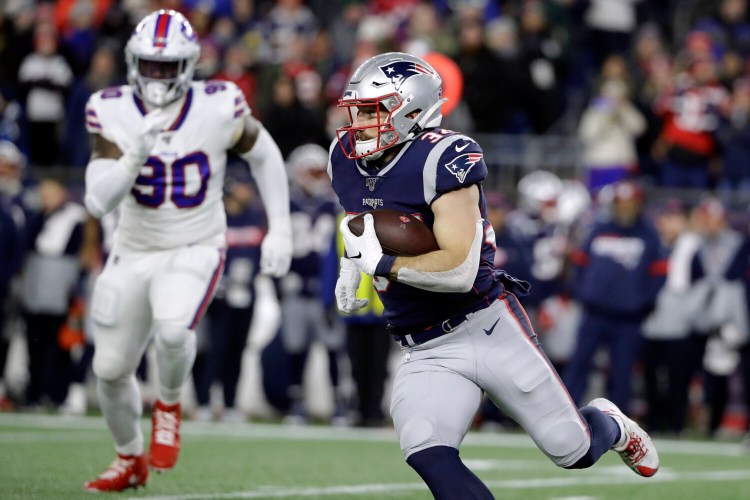 New England Patriots running back Rex Burkhead runs with the ball as Buffalo Bills defensive end Shaq Lawson (90) gives chase in the first half of an NFL football game, Saturday, Dec. 21, 2019, in Foxborough, Mass. (AP Photo/Steven Senne)