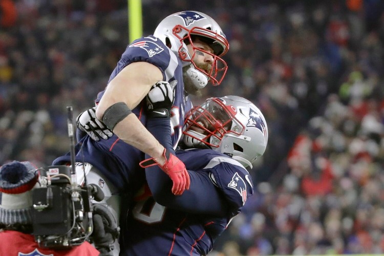 New England Patriots wide receiver Julian Edelman, top, gets a lift from offensive tackle Isaiah Wynn after catching a pass for a two-point conversion in the fourth quarter of the Patriots' 24-17 win over Buffalo on Saturday in Foxborough, Mass. 